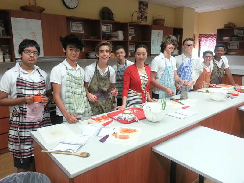 Ying and her students make dumplings during a school visit.